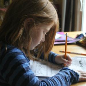 Girl sitting at table drawing