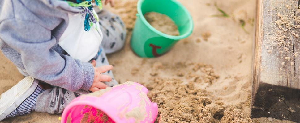 children's hands playing in the sand