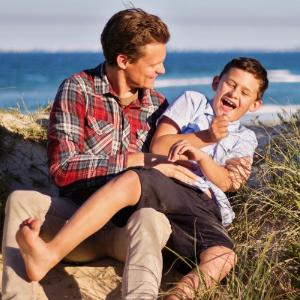 Man looking happy while making a teenager laugh