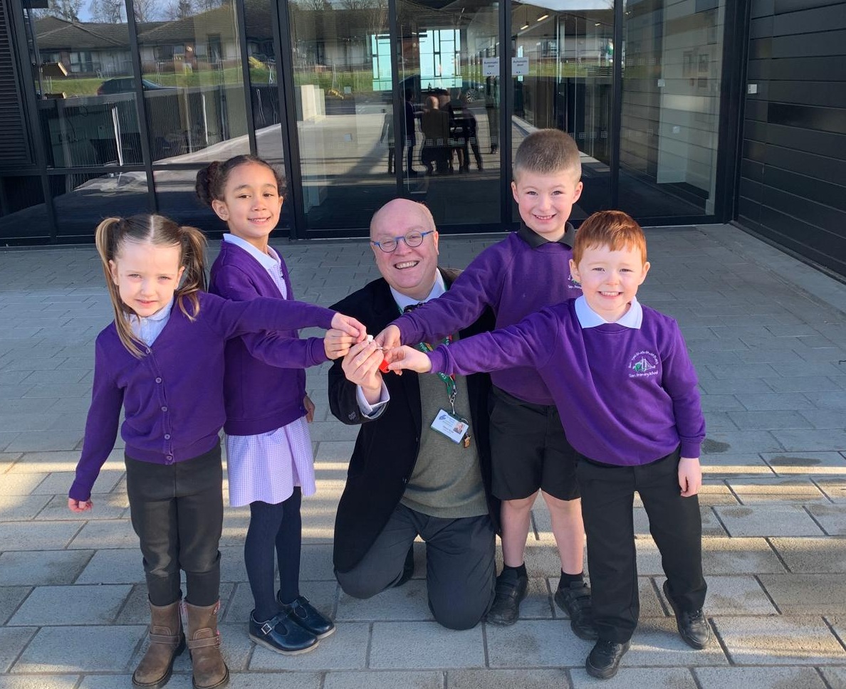 Four pupils with the head teacher standing outside Tain Campus with the keys to the new school.
